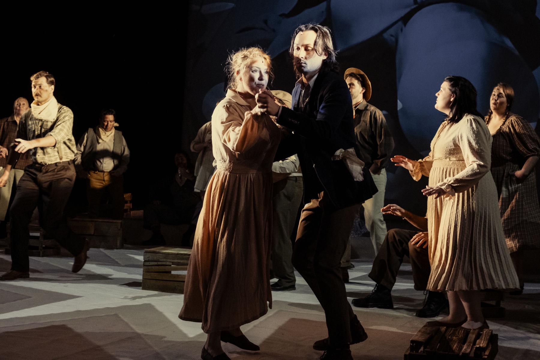 Dust Bowl staged movement scene with singers and projected imagery