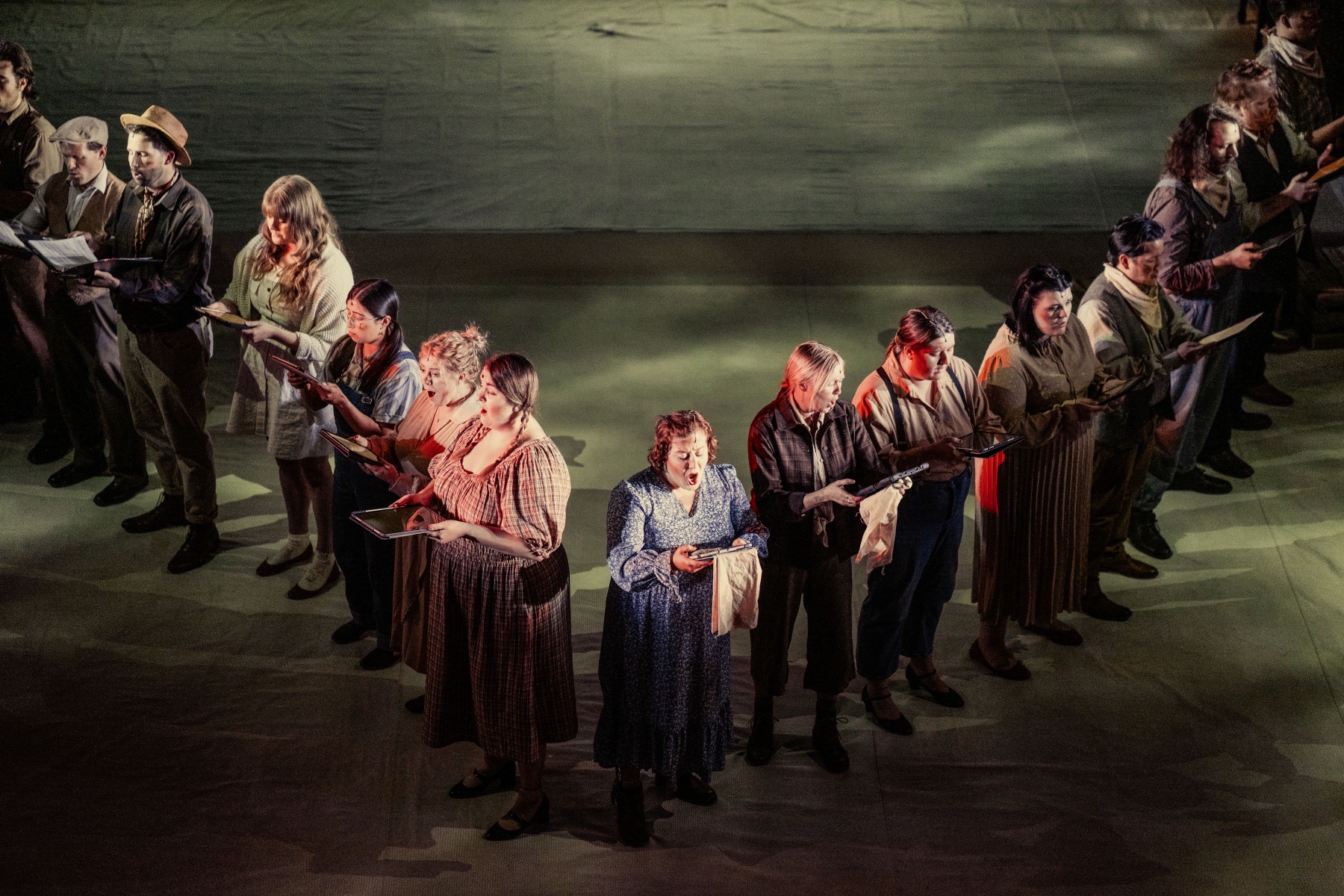 Dust Bowl ensemble singing from above with projected light on the floor