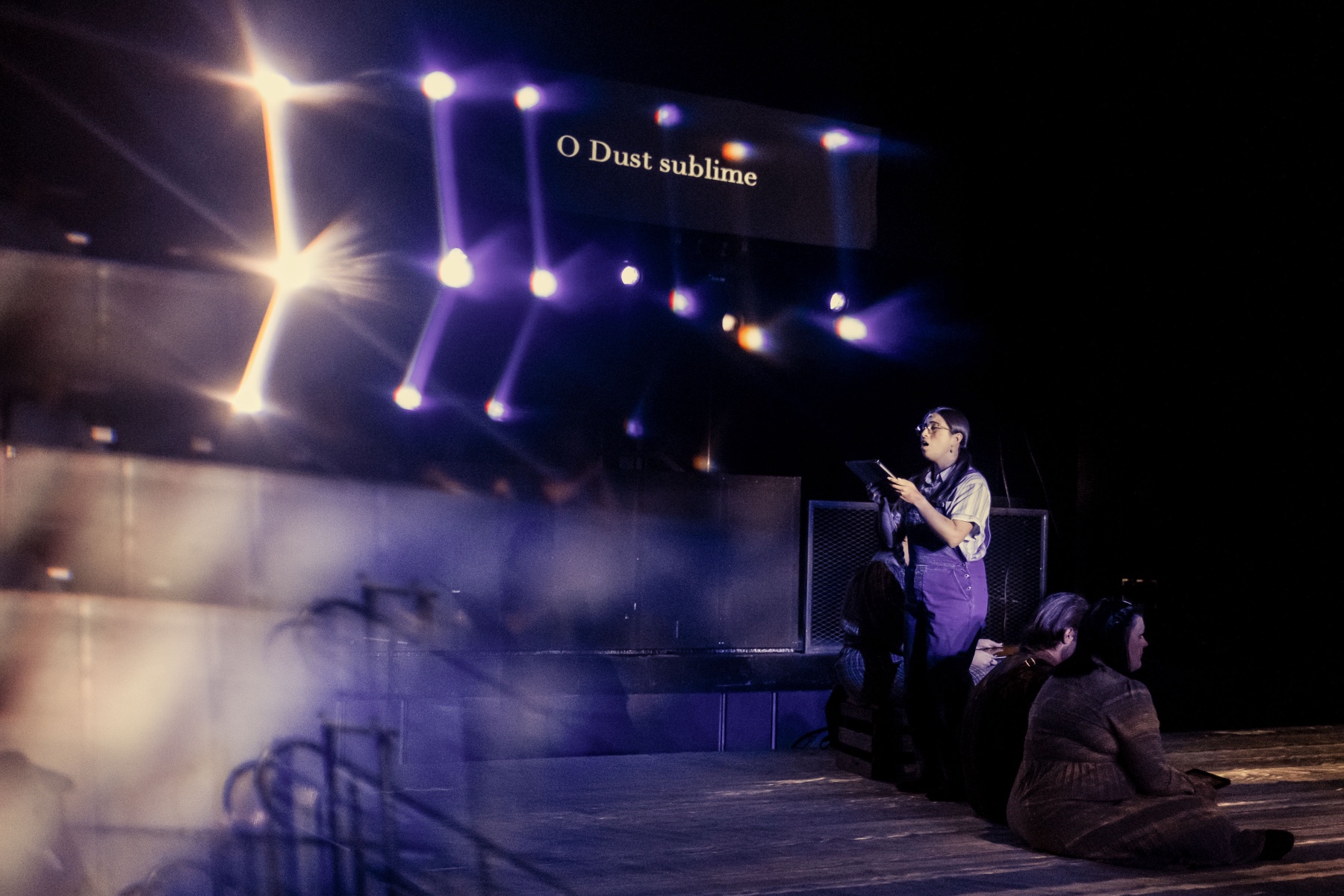 Dust Bowl singer under projected title text and stage lights