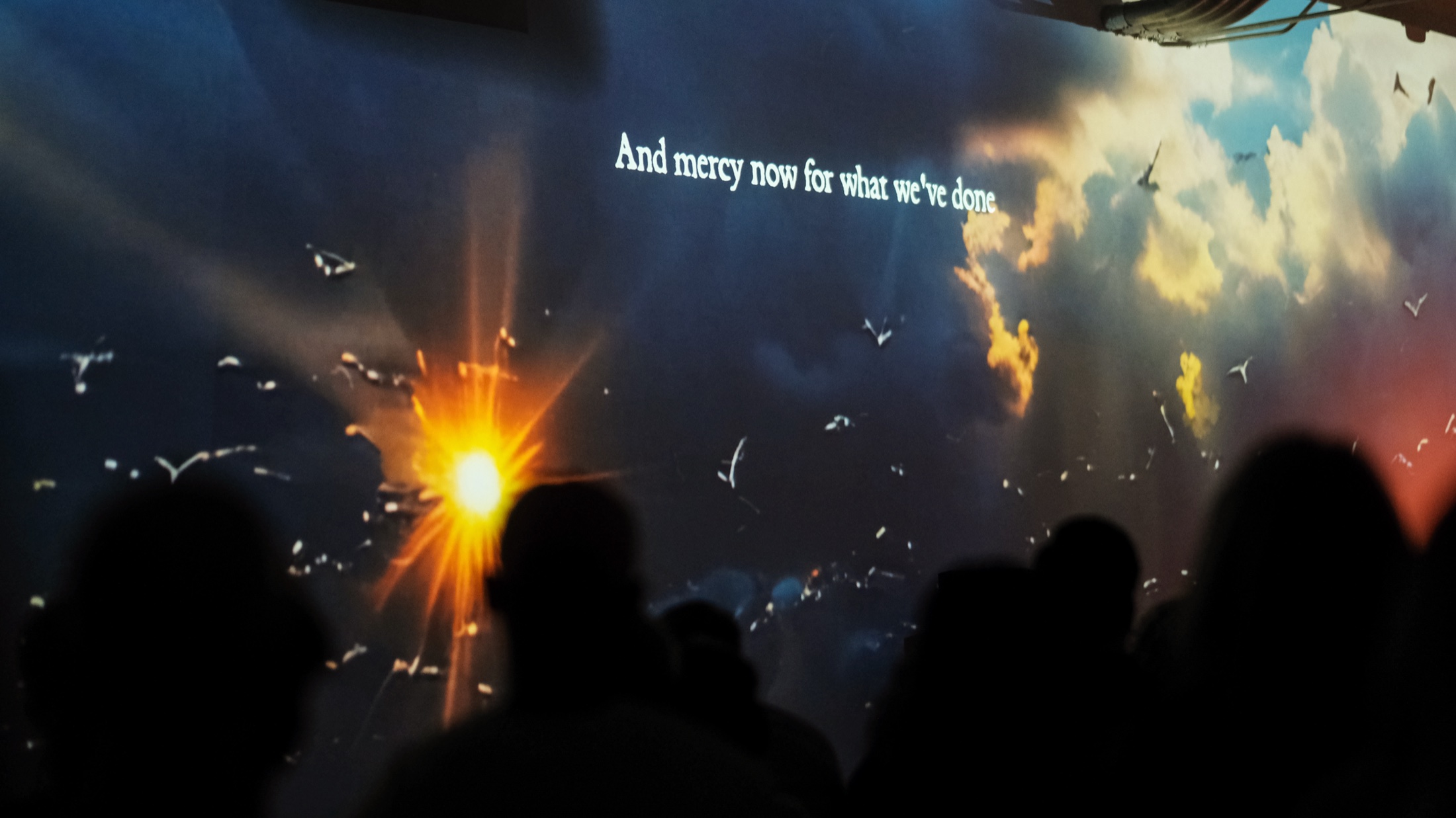 Projected lyric text on the wall during The Endangered