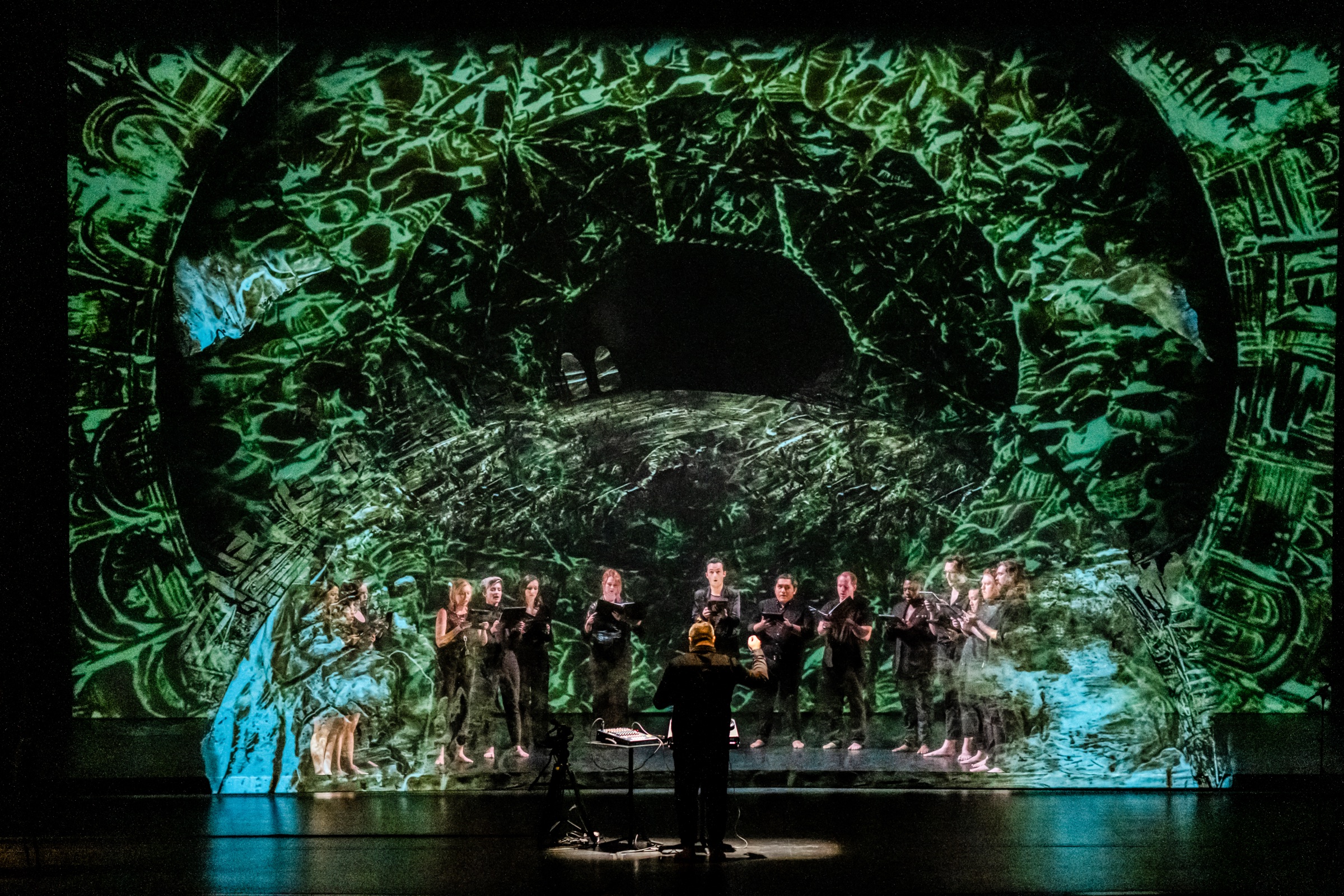 Verdigris Ensemble performing SHAMS beneath a green projected arch